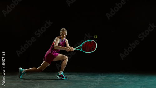 Competitive female tennis athlete lunging for shot on dark minimal background. Concept of determination, effort, elite sport mindset, dynamic movement, and professional athletic branding.