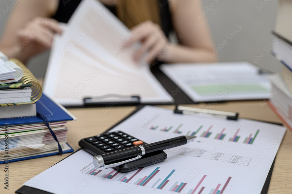 Fototapeta premium An accountant sitting at her desk at work, doing annual tax returns, training in KSEF