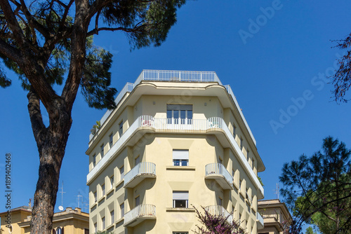 Italian Rationalist Architecture of Modern Apartment Building in Rome Italy featuring Curved Balconies and Rooftop Terrace framed by Mediterranean Umbrella Pines