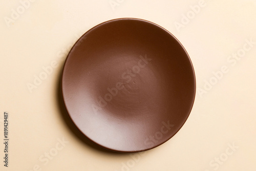 Wallpaper Mural Top view of isolated of colored background empty round brown plate for food. Empty dish with space for your design Torontodigital.ca