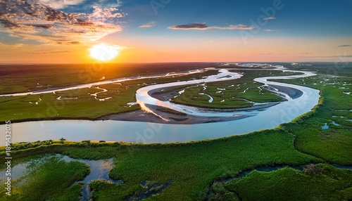 A Peaceful River Delta With Winding Waterways Surrounded By Lush Green Marshland Under A Vibrant Sunset Sky