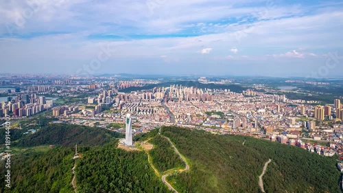 Aerial view of the cityscape of Wuhan, China, with a tower on a green hill