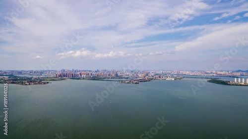 Wuhan city skyline and large lake under a cloudy sky