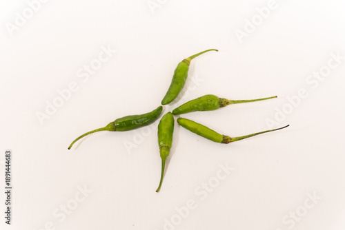 Fotografie Five green chilies isolated on a white background