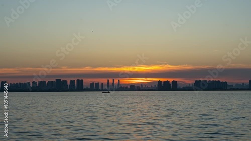 Sunset over the Wuhan skyline with a boat on the water