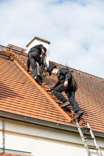 Wallpaper Mural Two chimney sweeps climbing up house roof Torontodigital.ca