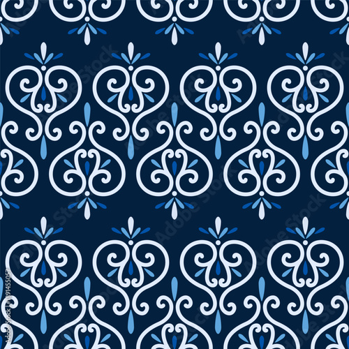 Winter frosty seamless pattern of vignettes. Classic stile border of swirls. White intricate swirly elements on dark blue background. Monochrome ornament in shades of blue
