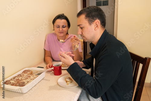 Caucasian couple enjoying breakfast with cinnamon rolls at home