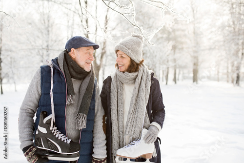 Senior couple with ice skates in winter landscape