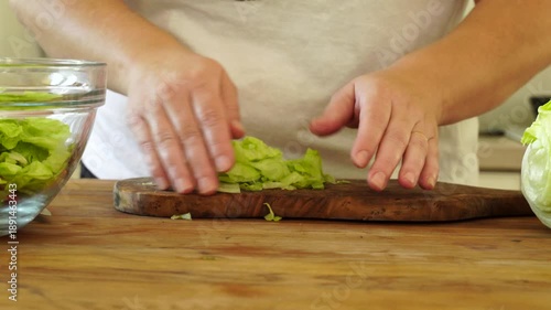 Woman cutting iceberg lettuce for salad
