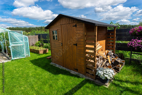 A wooden garden shed standing very close to the property fence.