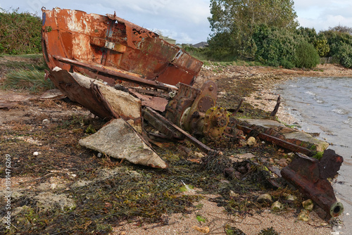 Foto A rusting old hulk of a boat lying on the shore