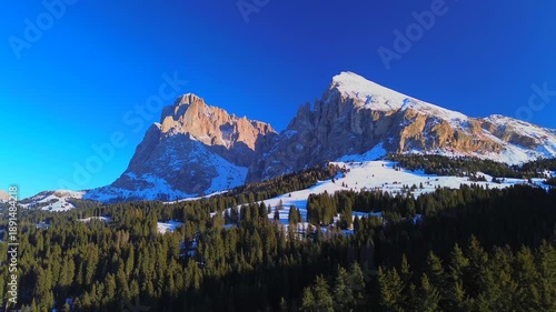 Aerial view. People skiing. Winter holidays. Snow-covered coniferous trees and roads on the tops of the Alpine mountains. Skier Winter. Wide angle drone view. Sun. Alpe di Siusi Italy 20.01.2026