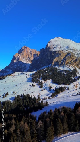 Aerial view. People skiing. Winter holidays. Snow-covered coniferous trees and roads on the tops of the Alpine mountains. Skier Winter. Wide angle drone view. Sun. Alpe di Siusi Italy 20.01.2026