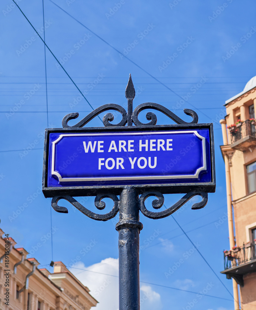 Fototapeta premium Support, help and we are here for you symbol. Concept words We are here for you on beautiful blue road sign. Beautiful blue sky background. Business we are here for you concept. Copy space.