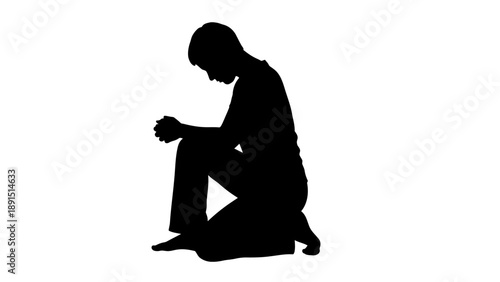 Silhouette of a person kneeling in prayer or contemplation.