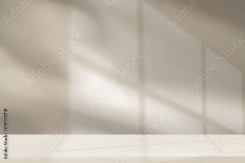 Beige background,Minimal wall with soft natural light shadow from window and empty podium for product backdrop display,cosmetic mocku.Light brown vibes in room,aesthetic background template mock up 