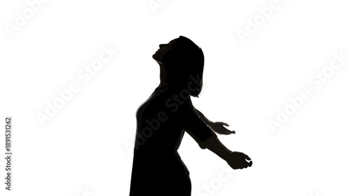 Silhouette of a woman with arms outstretched looking up.