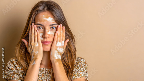 Woman applying facial mask with a calm expression in a serene, beige-toned setting during a relaxing self-care moment at home