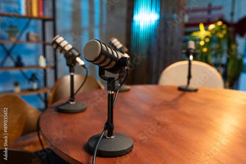 Podcast session with four microphones set up for recording in a studio space at evening time