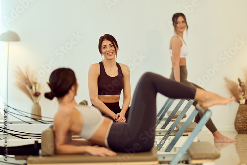 Wallpaper Mural Group Fitness Class With Women Doing Reformer Pilates In Bright Studio, Warm Atmosphere And Motivation Torontodigital.ca