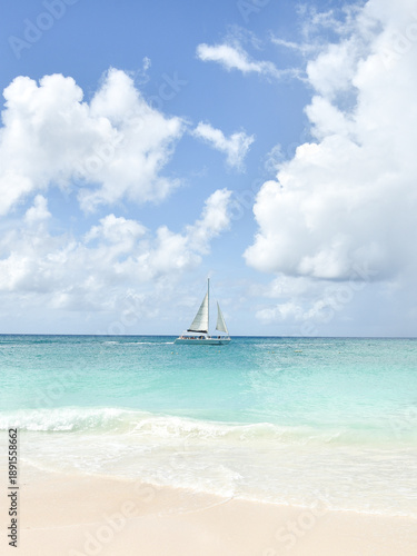A Sail Boat in the Caribbean Sea as Seen from a Beach in Aruba