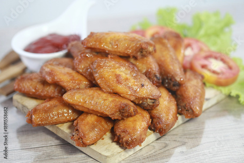 Wallpaper Mural Appetizing Chicken Wings Platter: A tempting assortment of golden-brown chicken wings, beautifully arranged with fresh vegetables and flavorful dipping sauce on a wooden board. Torontodigital.ca