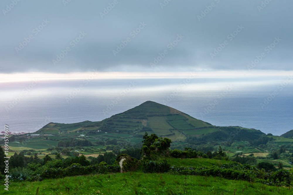 Fototapeta premium San Miguel, Azores. Green landscape with mountains and scenic views. Atlantic coastline in the distance. Rural setting with natural scenery.
