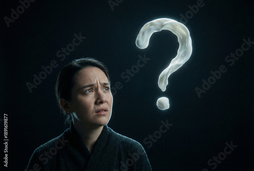Woman looking confused with question mark background in dark setting  