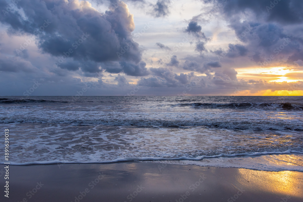 Fototapeta premium Sunset on Beach with Dark Clouds and Yellow Light