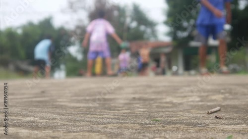 the concrete road surface with the background of children playing football is blurry or out of focus