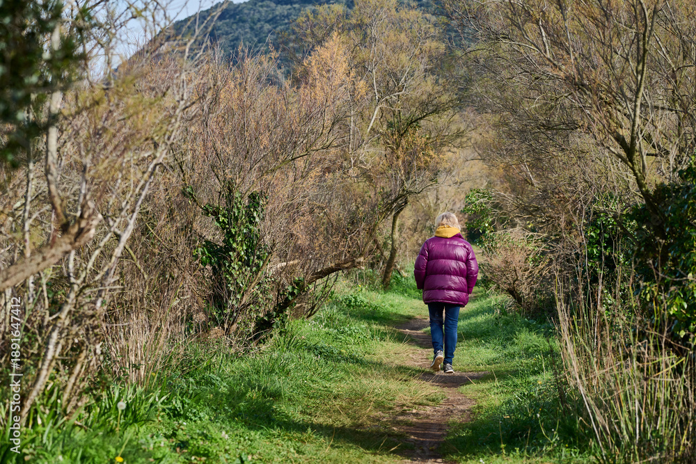 Fototapeta premium Woman walking on nature trail in early spring