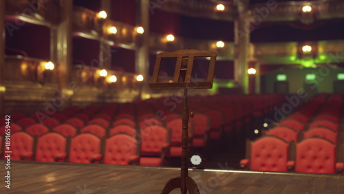 Obraz na plátně The scene captures a beautiful theater stage with an empty audience filled with red velvet seats