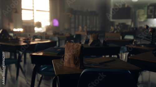 Fotografie Sunlight pours through the window of a quiet classroom, illuminating empty desks and scattered supplies