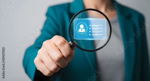 A person holds a magnifying glass over a glowing blue digital interface displaying a user profile with an avatar and details high quality professional detailed