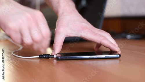 A man connects a dead mobile phone to a Type-C charger.