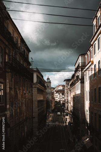 Moody Lisbon street scene with dramatic sky and old buildings