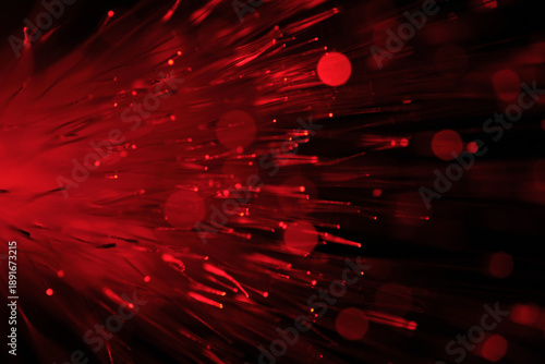 Close up red optical fibers with soft bokeh effect on dark background.