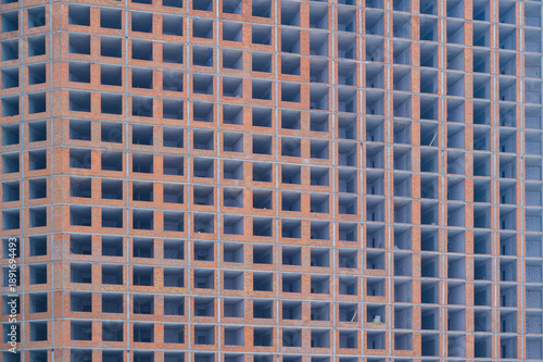 Fotografía Unfinished brick building showing its concrete frame and many empty window openi
