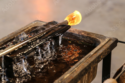 Photos Glowing molten glass on the end of a blowpipe