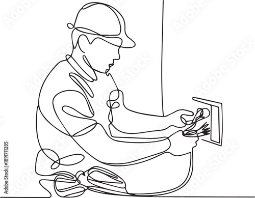 A worker installs an electrical outlet in a wall from a crouched viewpoint