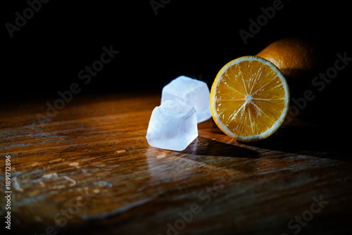 Fotografie Lemon slice and ice cubes with blue and orange neon lighting