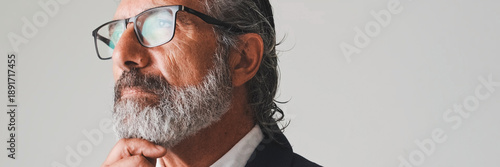 Wallpaper Mural Close up, middle-aged businessman in glasses with gray hair, hand props chin, isolated on gray background in the studio. Panoramic Torontodigital.ca