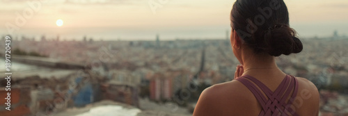 Close up, young woman in bodysuit practices yoga at sunrise at viewpoint. Back view. Panoramic. Panoramic