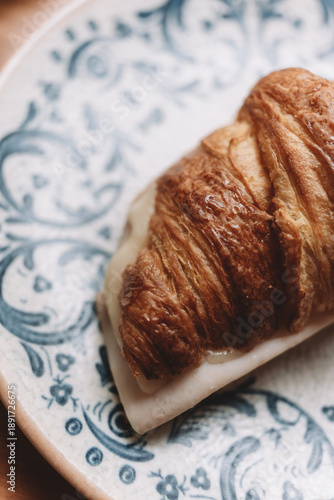 Cheese filled croissant served on ceramic plate