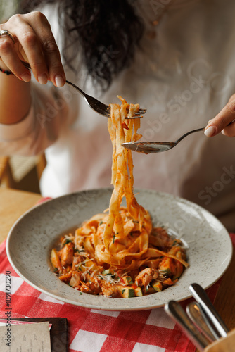 Tableau sur toile Close-up of female Hand Twirling Spaghetti on Fork in restaurant italian style