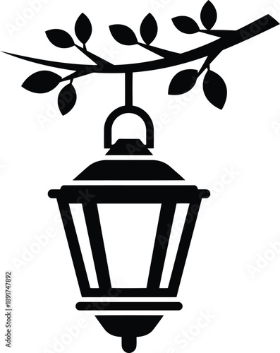 A black lantern hangs from a tree branch, surrounded by leaves, in a serene outdoor setting, viewed from below.