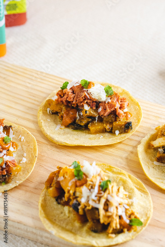 Assorted Mexican Tacos with Chicken and Vegetables on Wooden Board