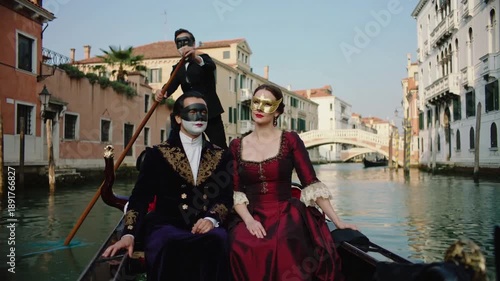 Romantic couple wearing traditional Venetian carnival masks riding a gondola through canals of Venice, Italy. Cinematic travel scene, luxury tourism and European culture