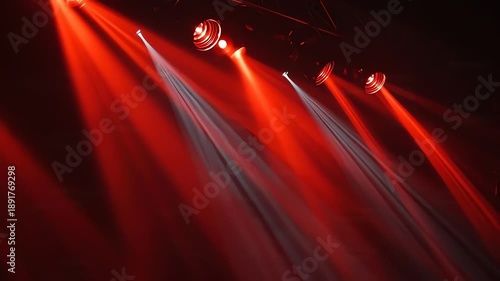 Dynamic stage spotlights projecting vibrant red and white light beams for exciting concert performance background